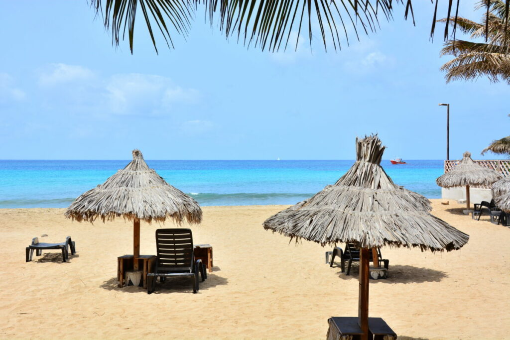 Sun umbrellas, beach umbrellas on a sandy beach and a blue, turquoise ocean, sea on Sal Island in Cape Verde, Cabo Verde