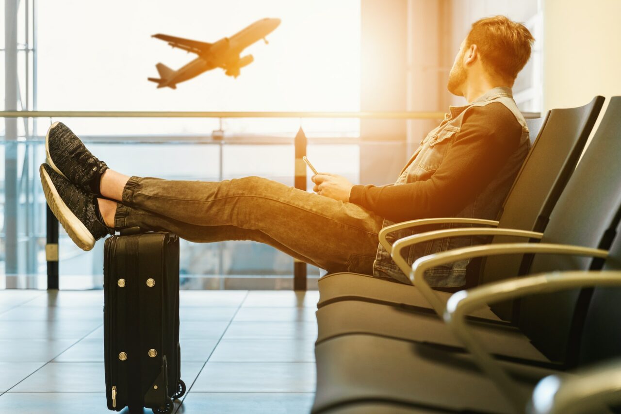 homem no aeroporto a espera de ir para um destino aproveitar os feriados de 2024