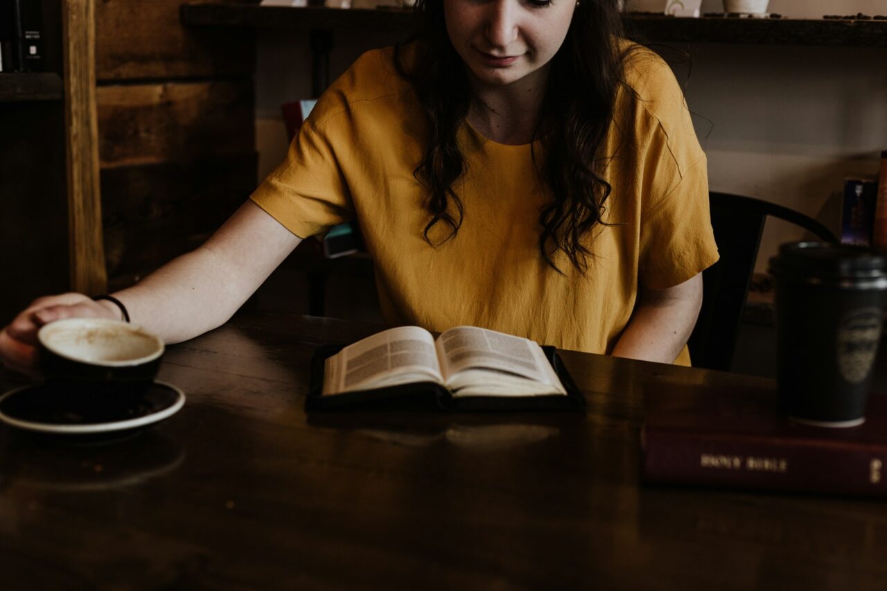 Mulher a ler um livro num café