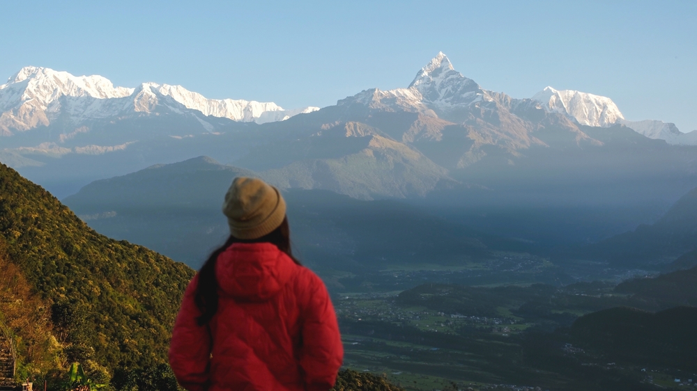 Mulher viajando no pico Machapuchare, serra de Annapurna / Farknot Architect / Shutterstock